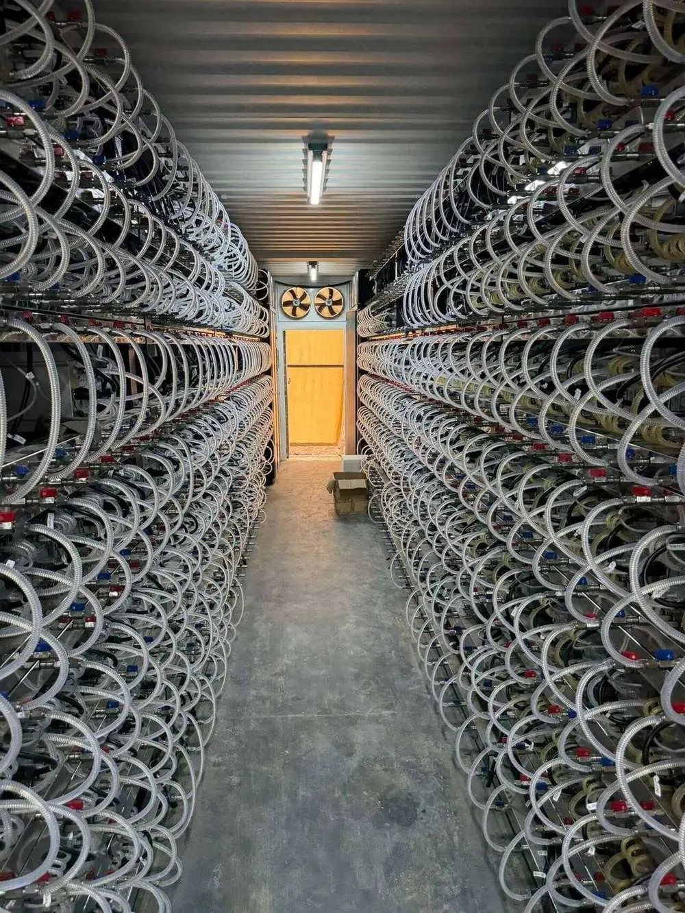 Salle d'hébergement hydro-cooling — allée de machines ASIC